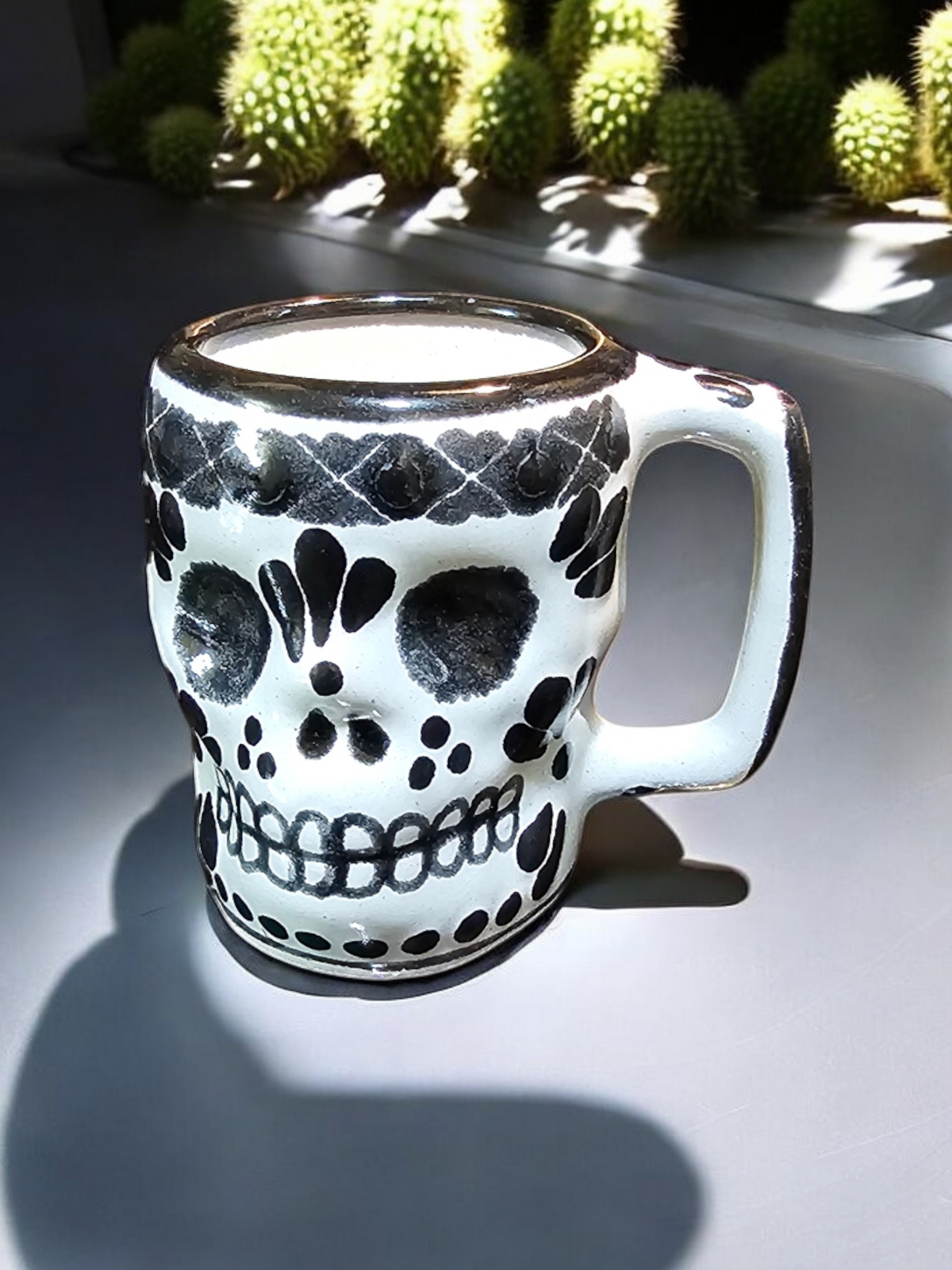 The Vela Lady Calavera shot lead-free barro candle in white and black hand-painted Mexican Talavera ceramic with skull design.