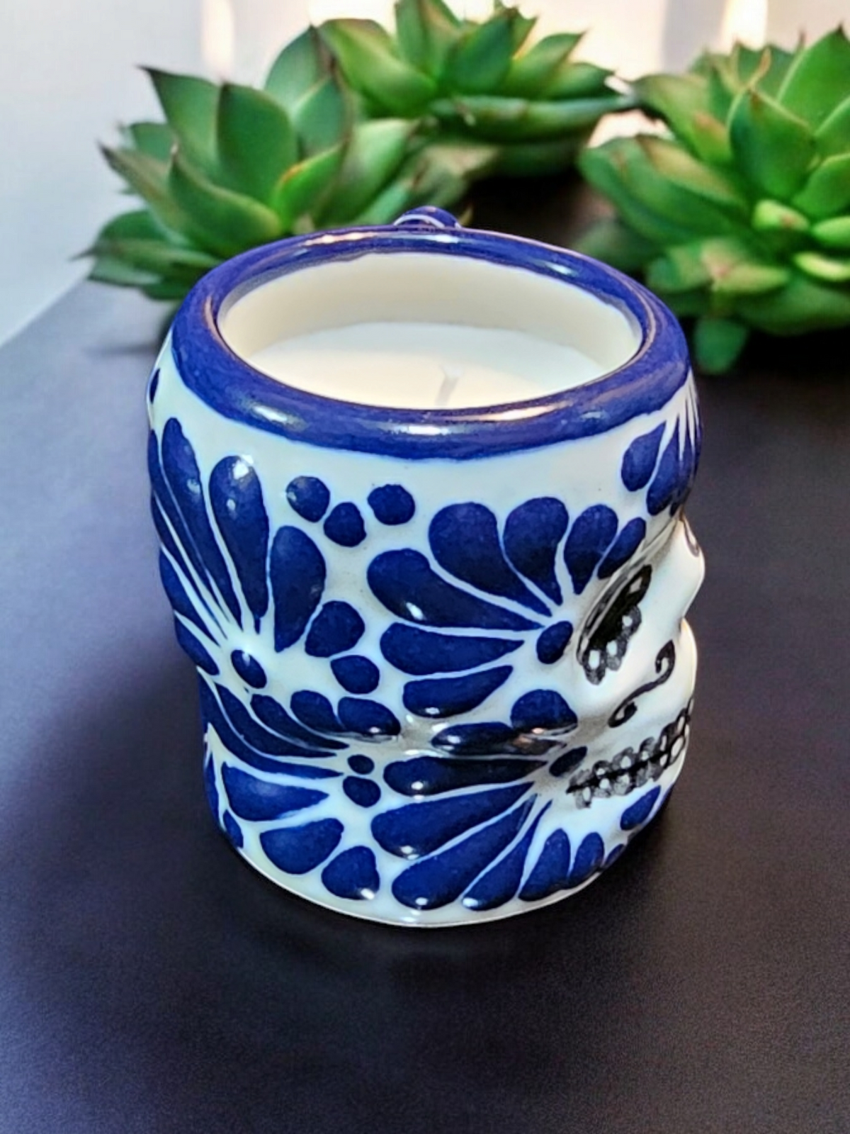 The Vela Lady Calavera shot glass candle in blue and white hand-painted Mexican Talavera ceramic with soy wax.