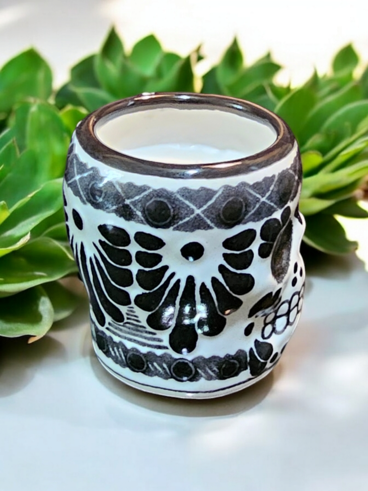 The Vela Lady Calavera shot glass soy candle in white and black hand-painted Mexican Talavera ceramic