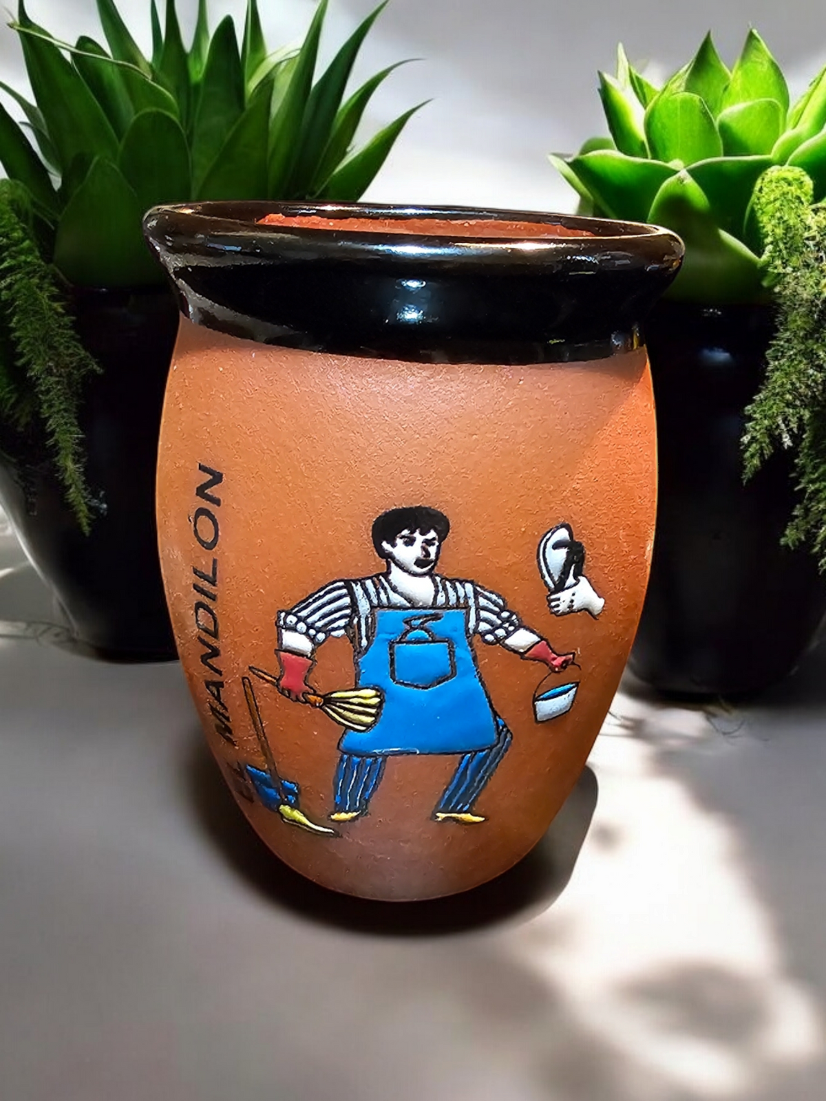 The Vela Lady El Mandilon cantarito soy candle in a handmade Mexican barro pottery vessel with hand-painted art.