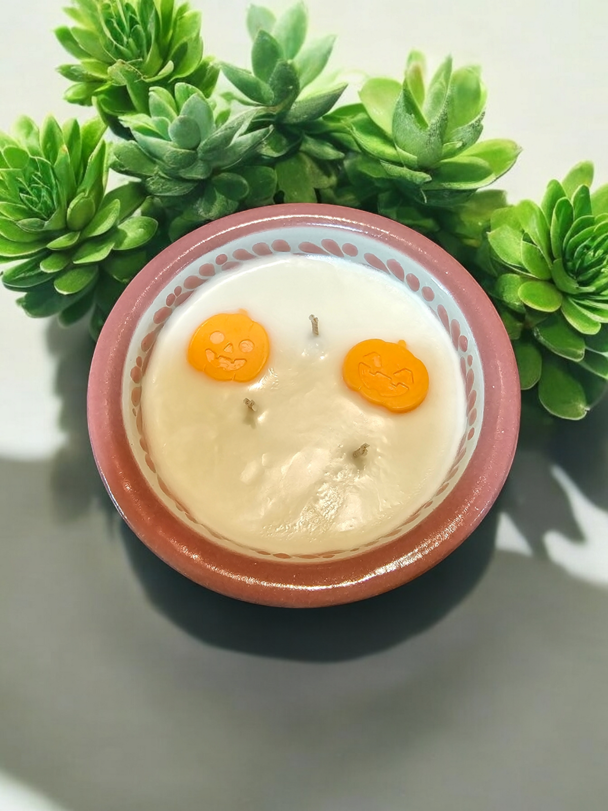 The Vela Lady handcrafted Talavera salsa bowl soy candle with orange pumpkin wax embeds and green succulent decor