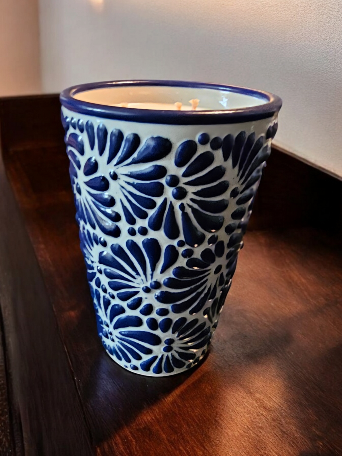 The Vela Lady soy candle in a blue and white hand-painted Mexican Talavera pottery vessel with floral patterns.