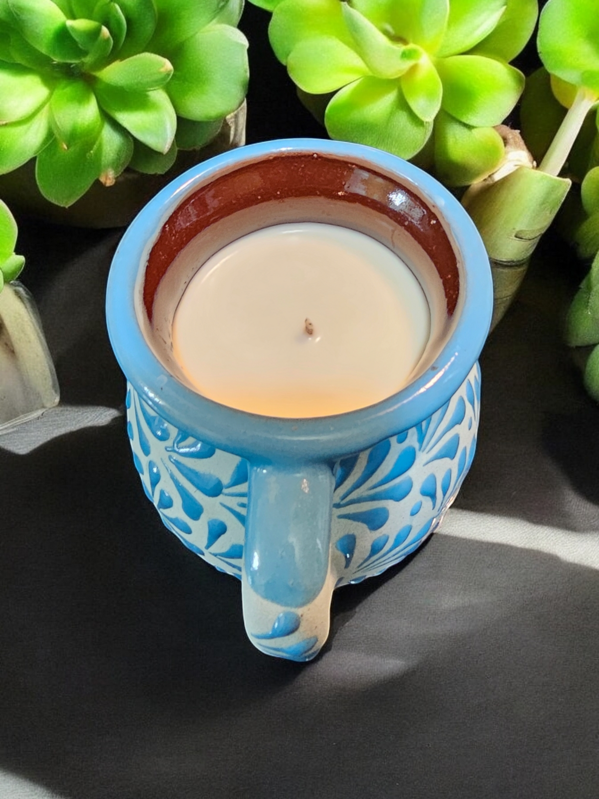 The Vela Lady blue hand-painted Mexican barro mug candle with soy wax, featuring intricate floral patterns.