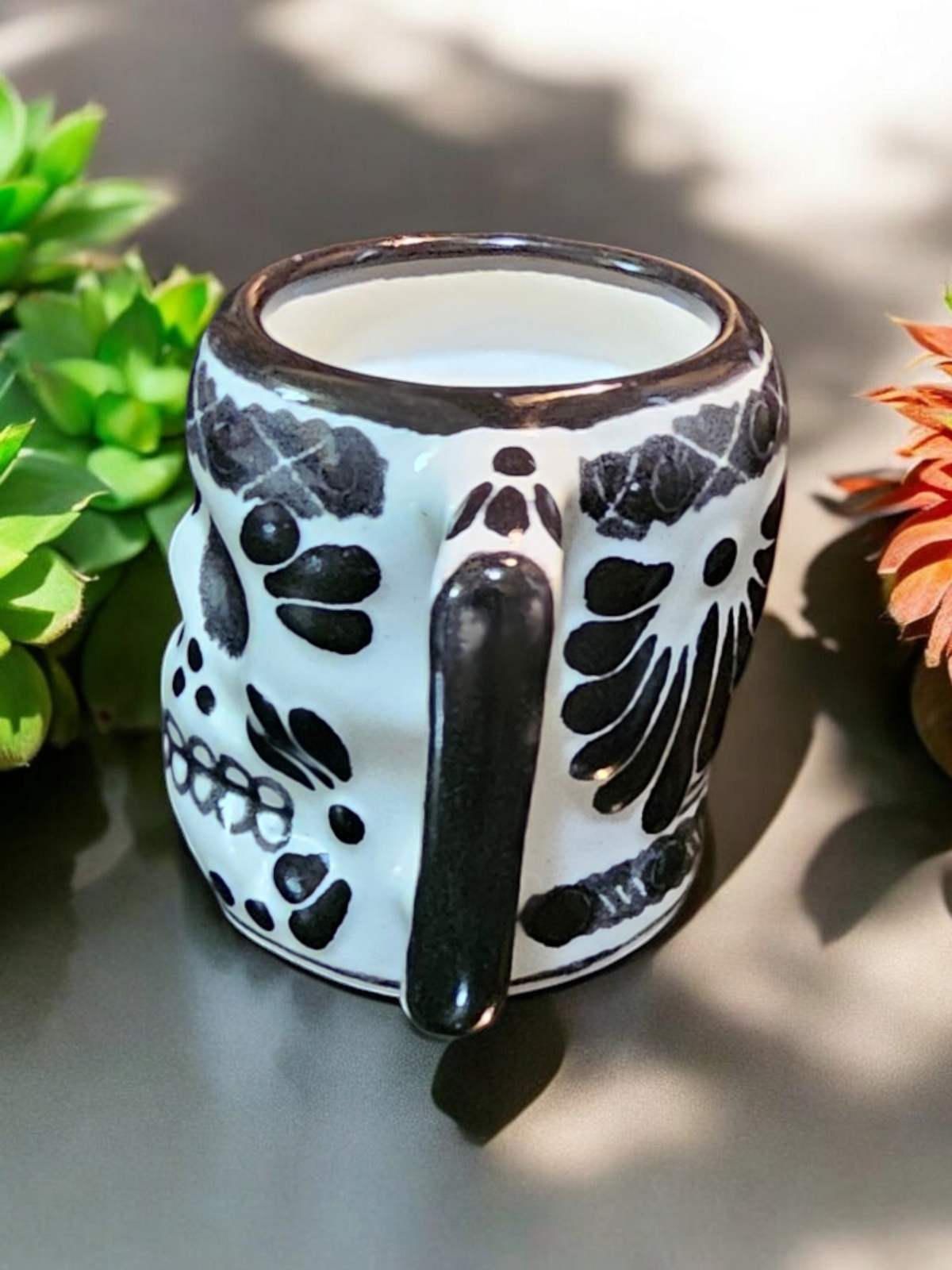 The Vela Lady Calavera shot glass candle in white and black hand-painted Mexican Talavera ceramic with skull design.