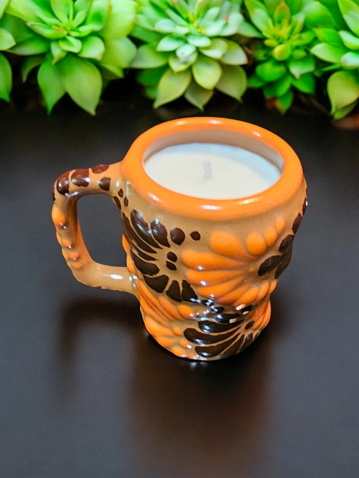 The Vela Lady Calavera shot glass soy candle in orange and brown hand-painted Mexican Talavera ceramic