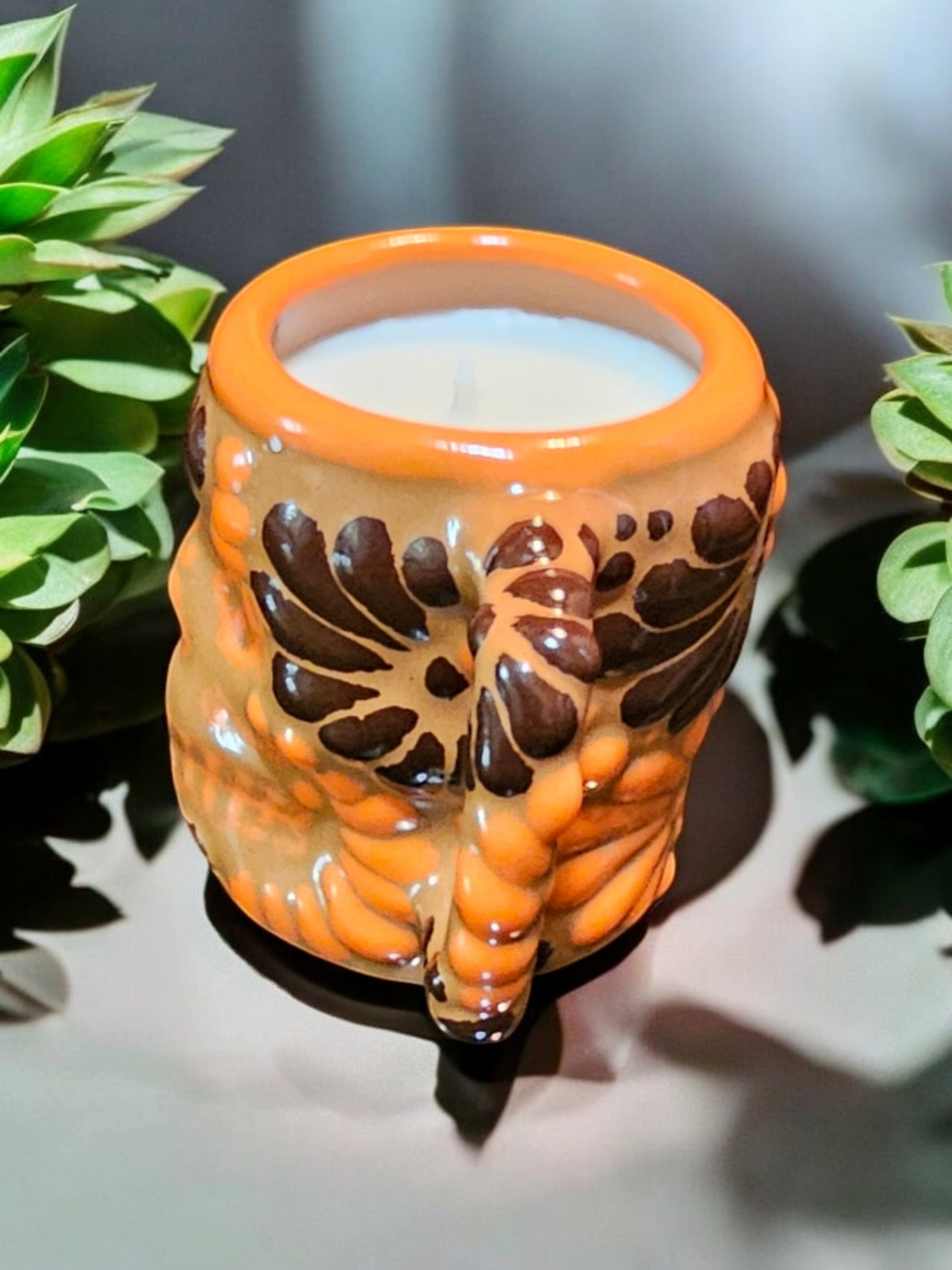 The Vela Lady Calavera shot glass candle in orange and brown hand-painted Mexican Talavera ceramic with soy wax