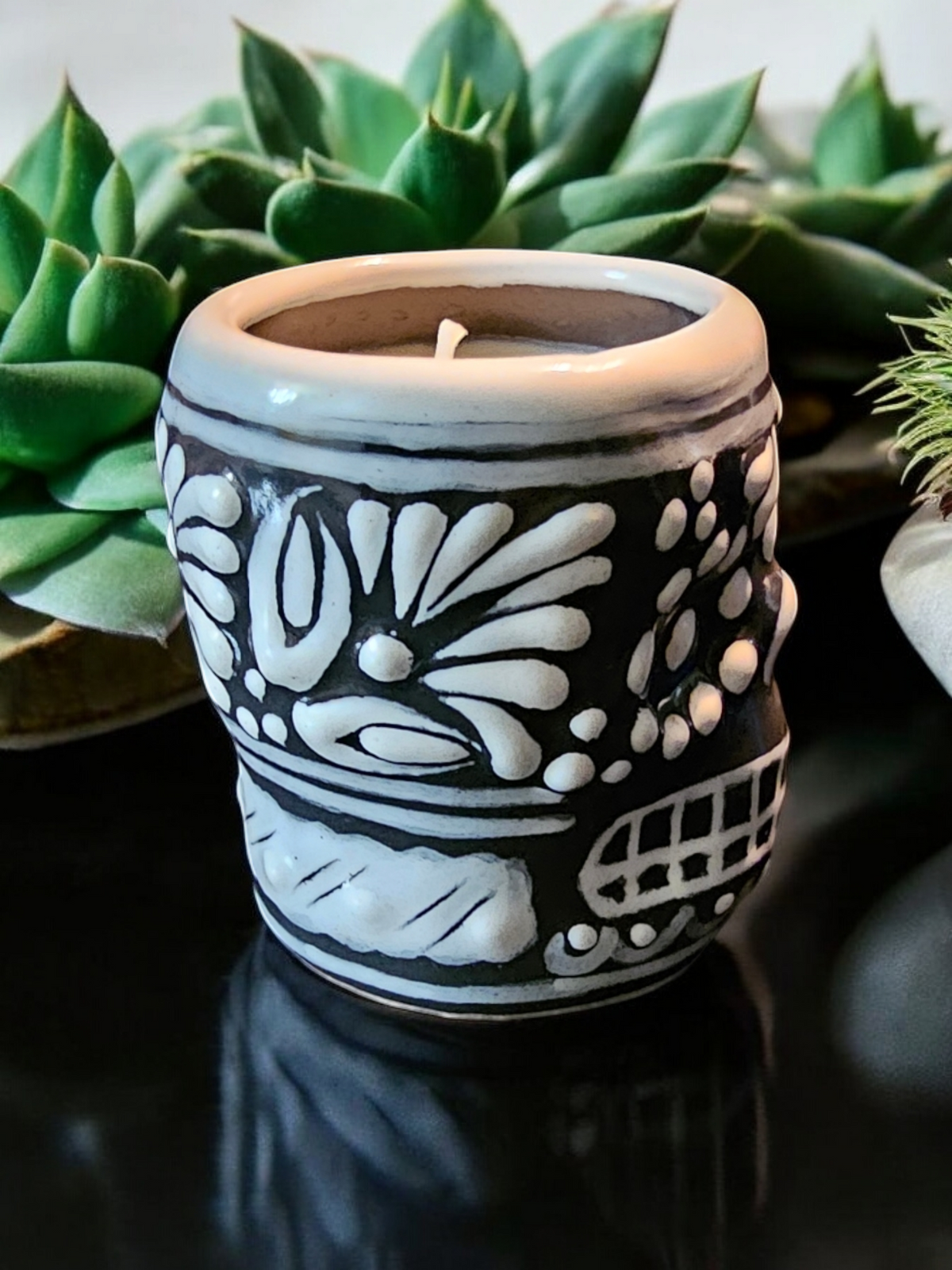 The Vela Lady Calavera shot glass candle in black and white Talavera ceramic with intricate hand-painted skull design.