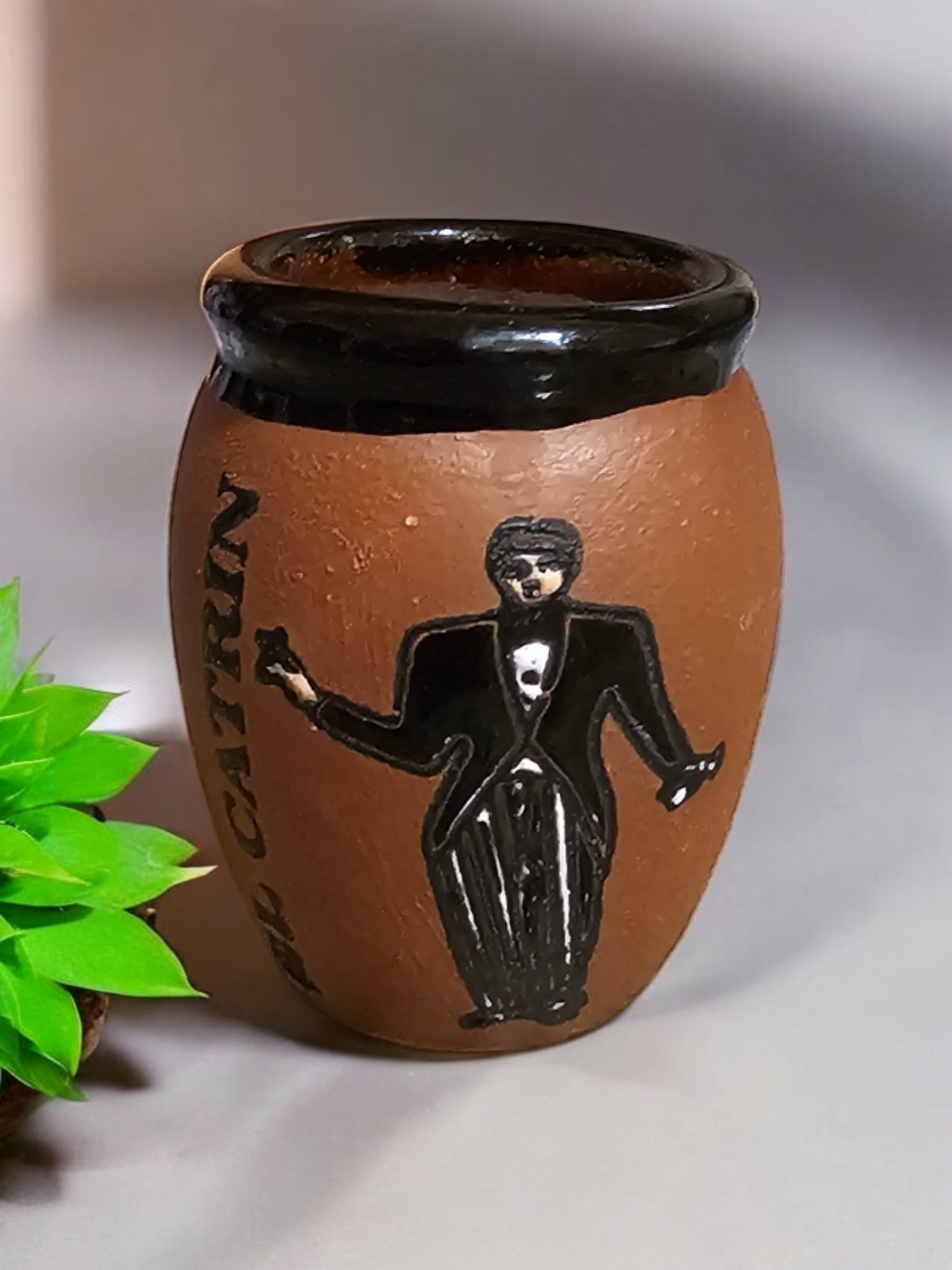The Vela Lady El Catrin Loteria cantarito soy candle in a handmade brown Mexican barro pottery shot glass vessel.