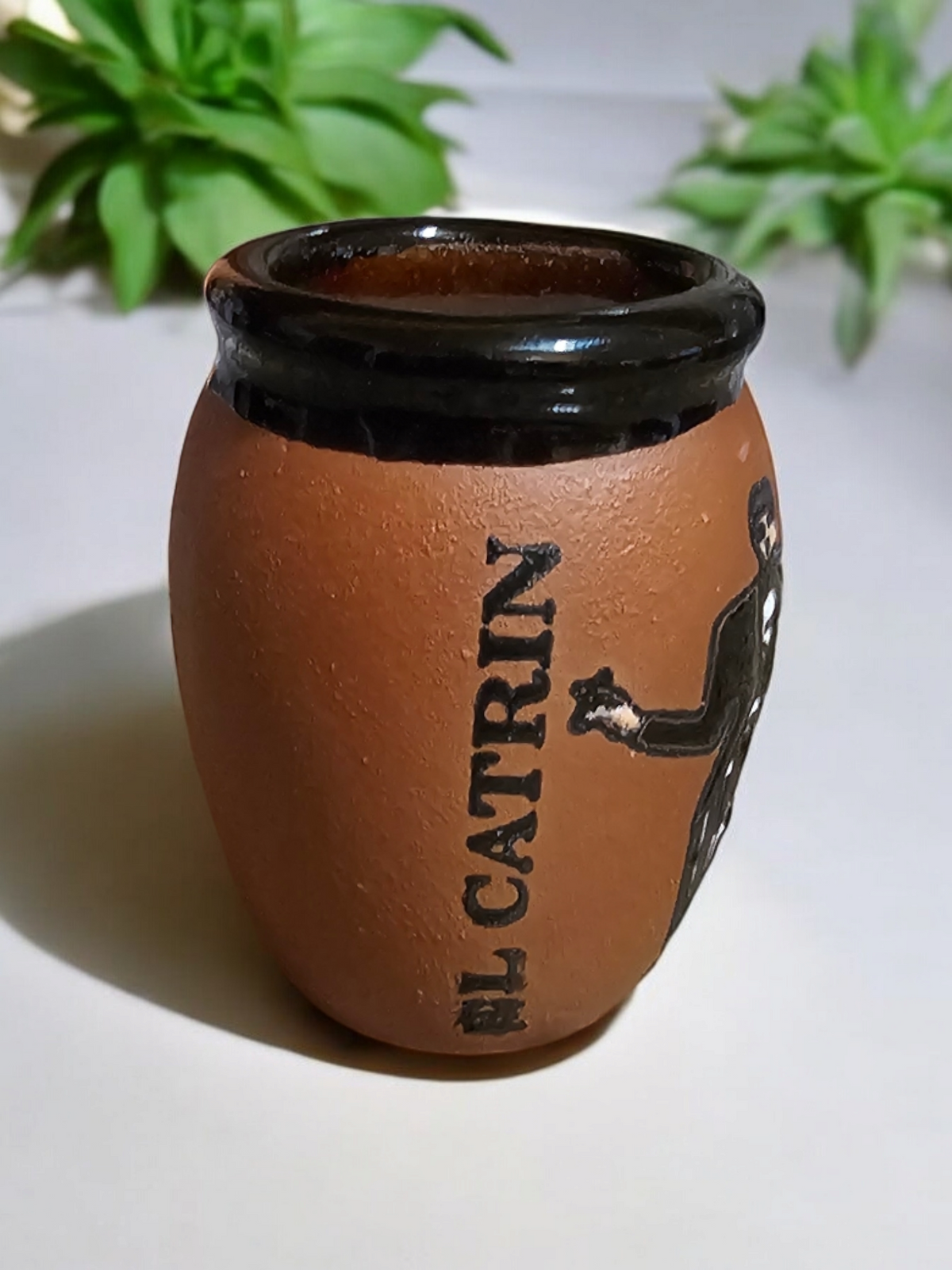 The Vela Lady El Catrin Loteria cantarito soy candle in a handmade Mexican clay shot glass vessel.