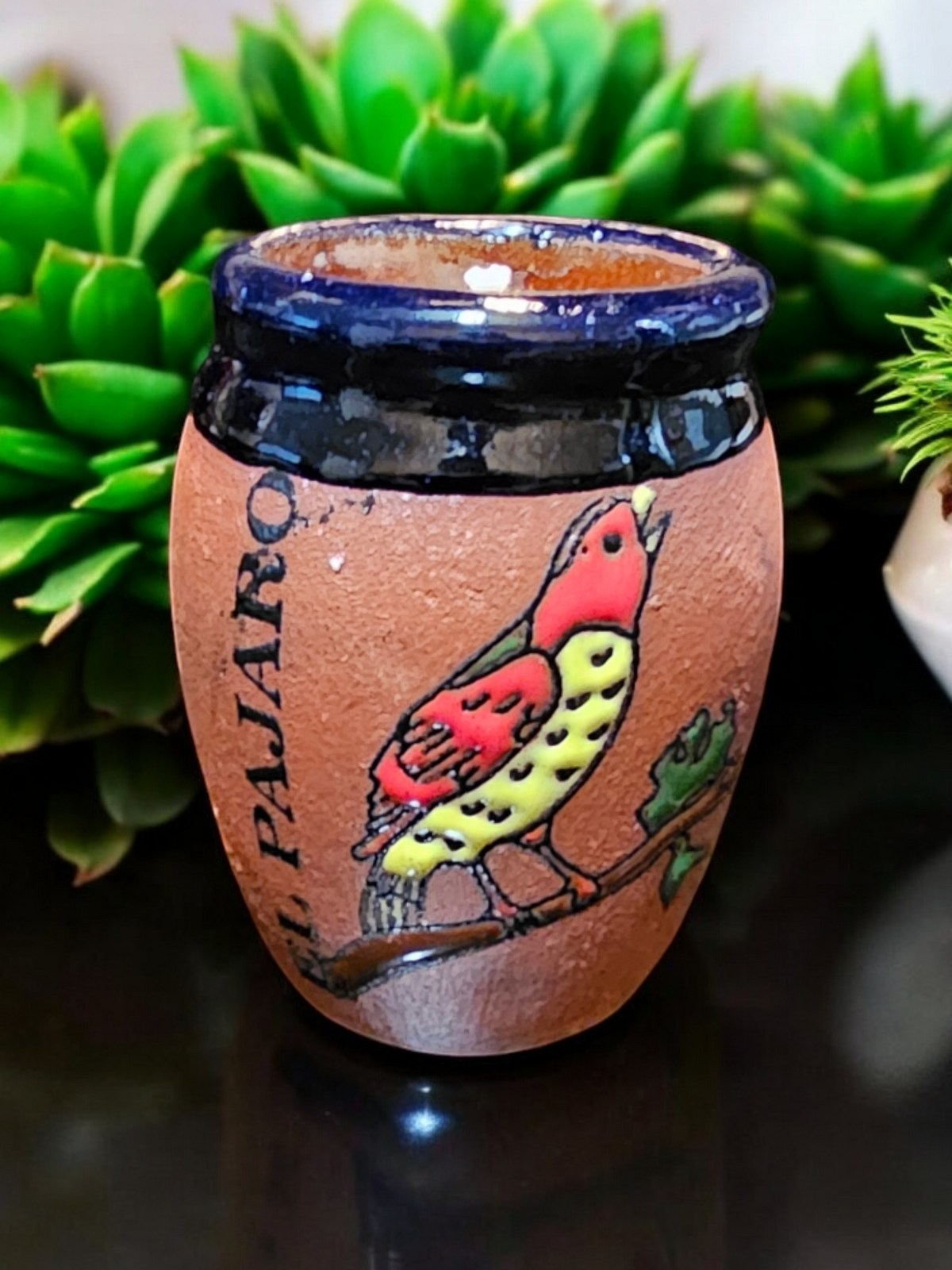 The Vela Lady El Pajaro Loteria soy candle in a handmade, hand-painted Mexican lead-free barro ceramic pottery shot glass vessel.