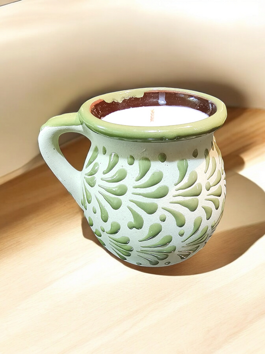 The Vela Lady green handmade Mexican barro mug candle with agua fresca scent and hand-painted decorative patterns