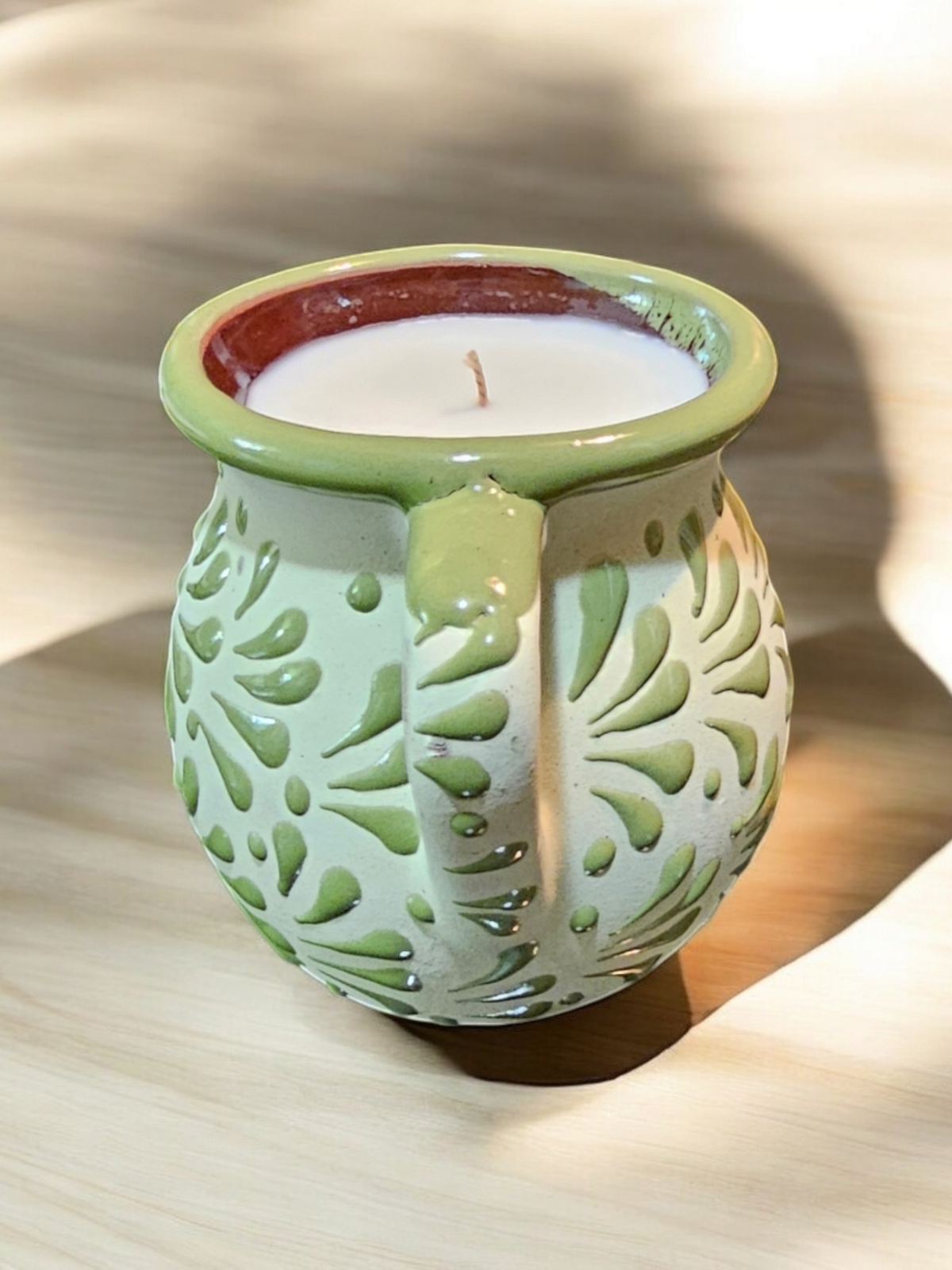 The Vela Lady green handmade Mexican barro mug candle with agua fresca scent and soy wax in a decorative pottery cup