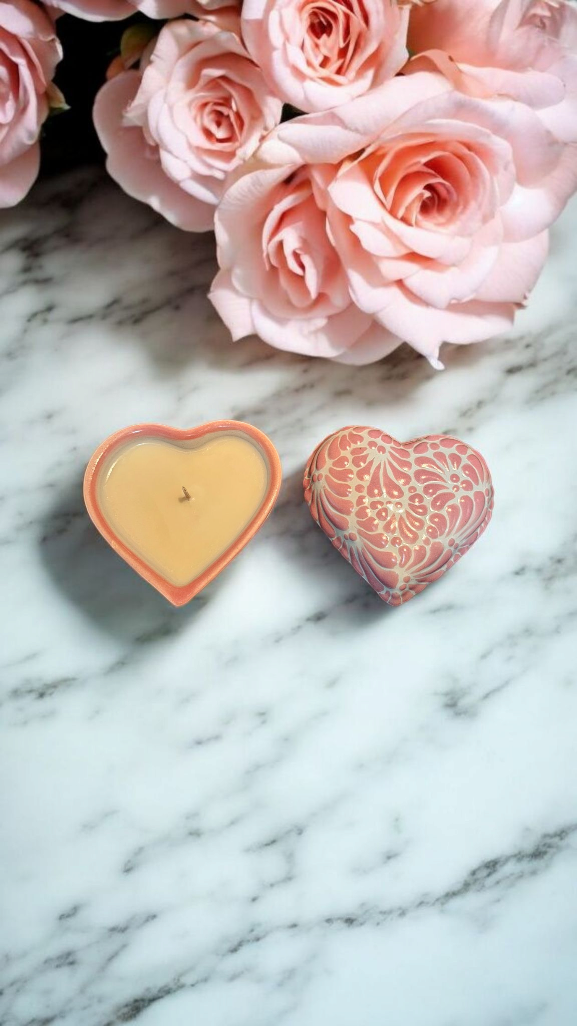 The Vela Lady heart-shaped pink Talavera ceramic candle and matching lid on a marble surface with pink roses