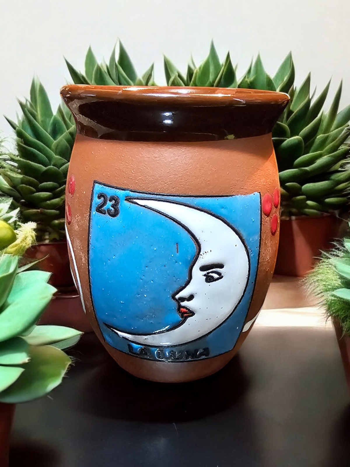 The Vela Lady La Luna Loteria cantarito soy candle in a handmade Mexican barro clay vessel with a moon design.