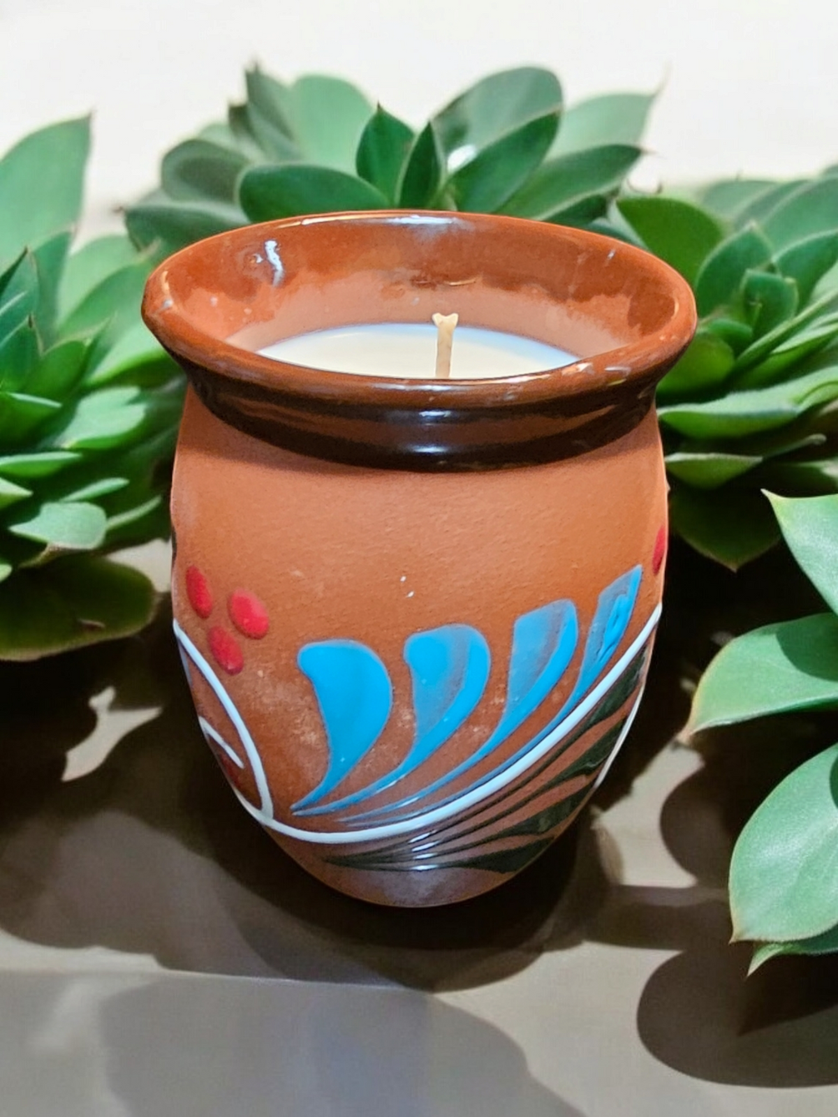 The Vela Lady La Luna Cantarito soy wax candle in a handmade, hand-painted Mexican barro clay cup with floral design.