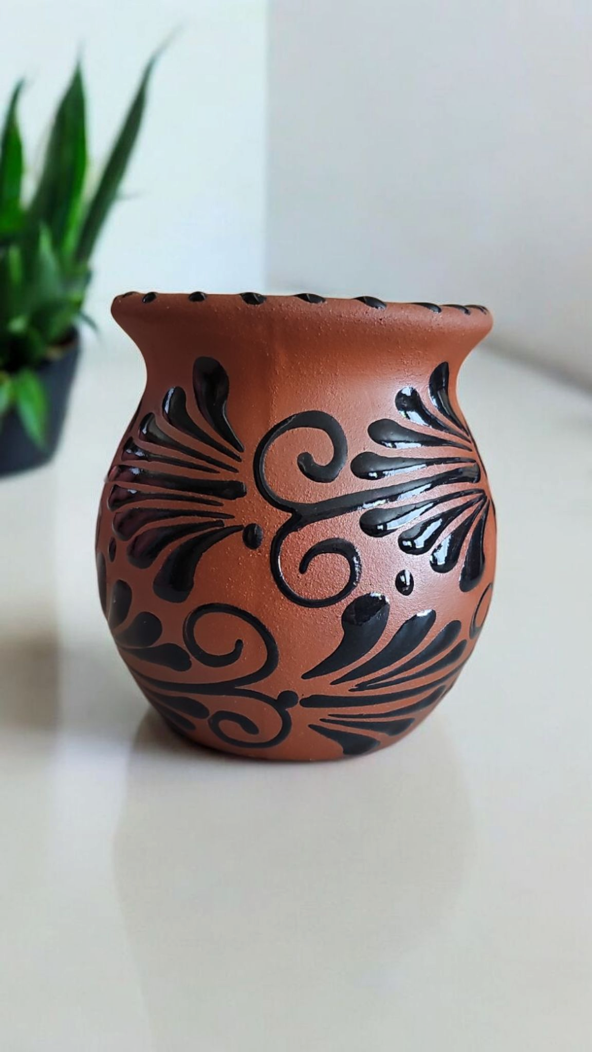 The Vela Lady handmade Mexican barro mug candle featuring a traditional dark clay vessel with black espiga design.
