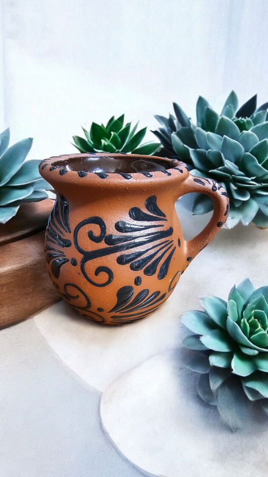 The Vela Lady handmade Mexican barro mug candle featuring a dark brown finish with a black hand-painted espiga design.