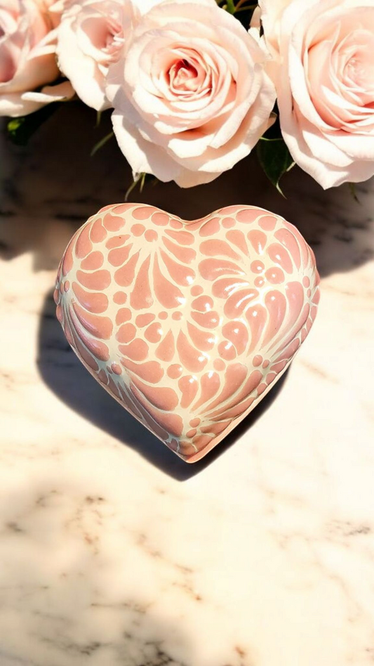 The Vela Lady heart-shaped pink and white Talavera ceramic trinket holder with floral patterns on a marble surface.