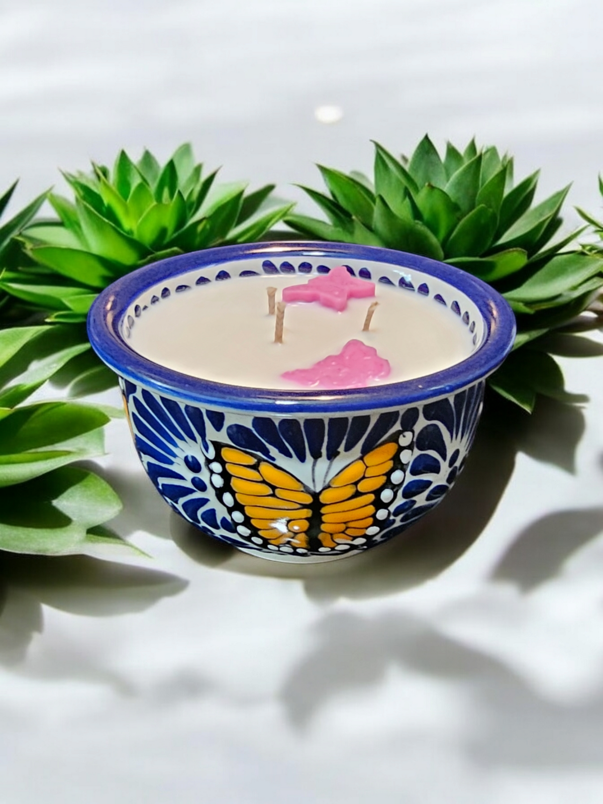 The Vela Lady handcrafted blue and white Talavera salsa bowl candle featuring a butterfly design and soy wax.