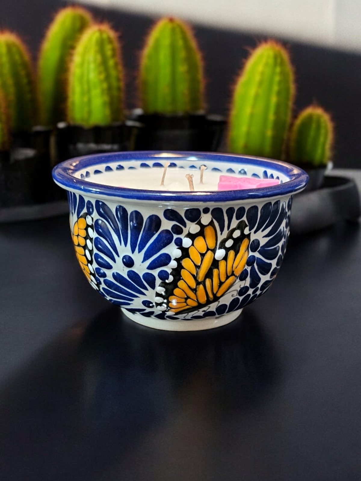 The Vela Lady handcrafted blue and white Talavera salsa bowl candle featuring butterfly designs and soy wax.