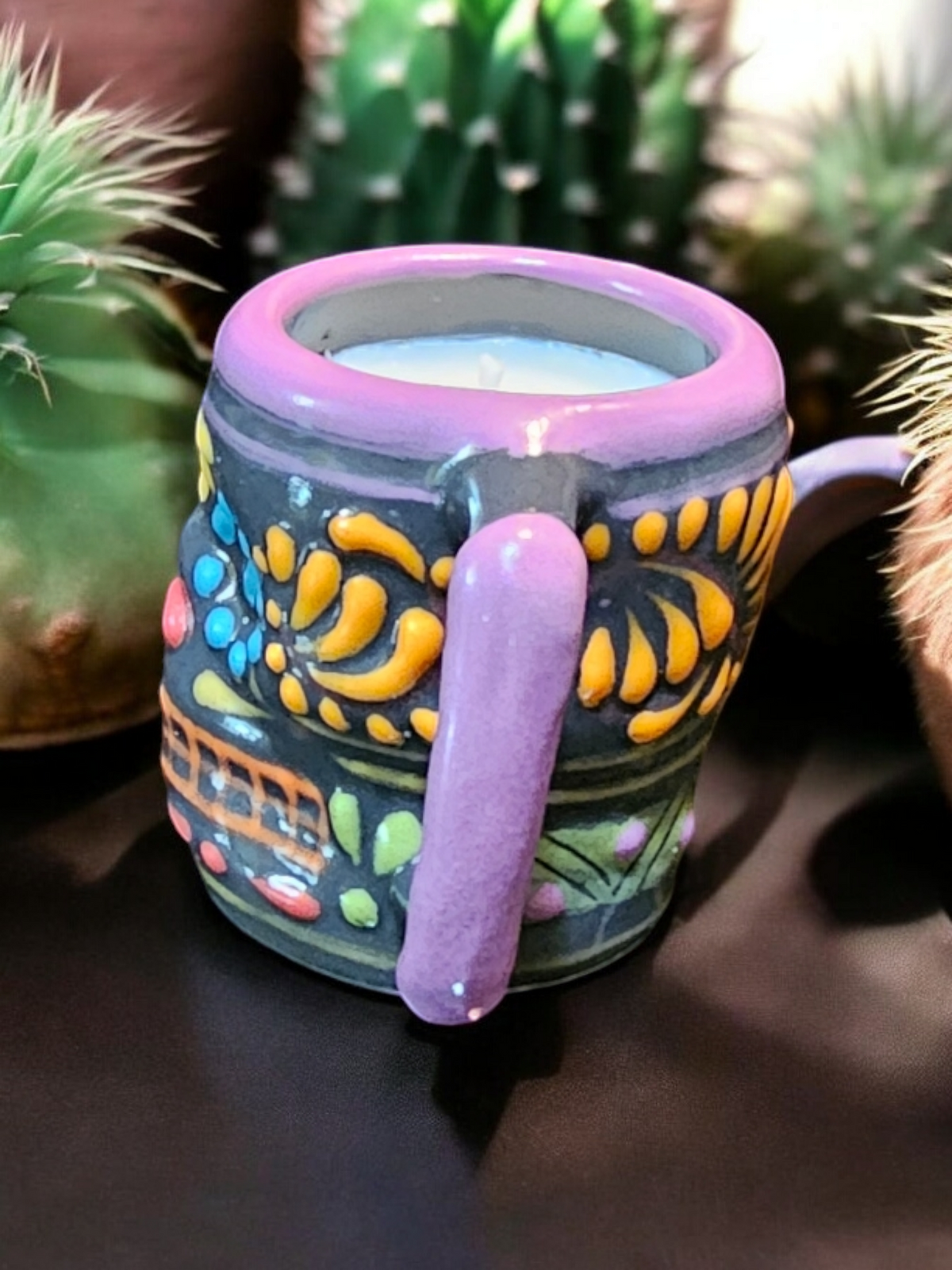The Vela Lady Calavera shot glass candle with hand-painted Mexican Talavera pottery in vibrant purple and orange.