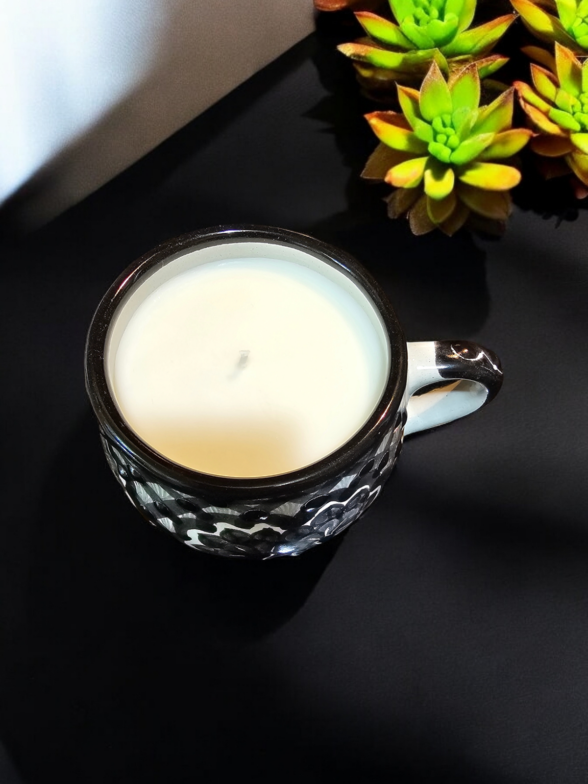 The Vela Lady La Catrina Talavera mug candle with white soy wax in a black and white hand-painted Mexican ceramic cup.