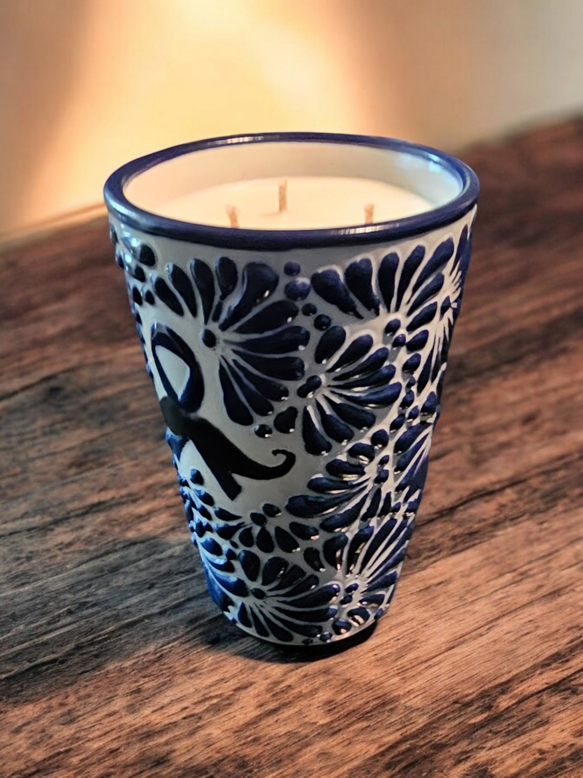 The Vela Lady soy wax candle in a blue and white hand-painted Mexican Talavera pottery vessel with mustache design.