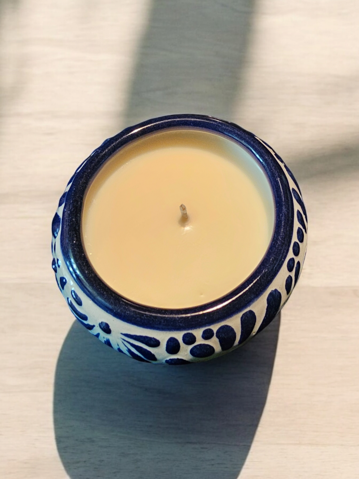 The Vela Lady blue and white Talavera ceramic candle vessel with soy wax, featuring traditional Mexican patterns.