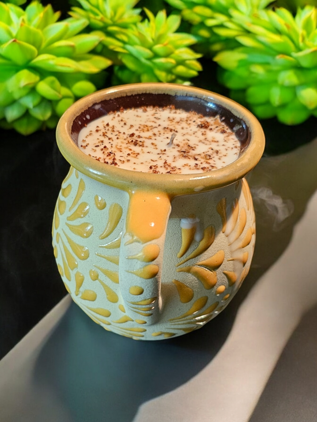 The Vela Lady yellow handmade Mexican barro mug candle with Mangoneada scent and decorative spice topping